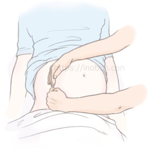 助産師が妊婦の腹部に手を当てて、子宮を左側に寄せている様子