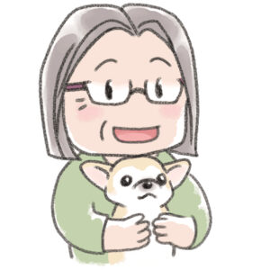 チワワを抱っこした初老の女性飼い主が笑っている